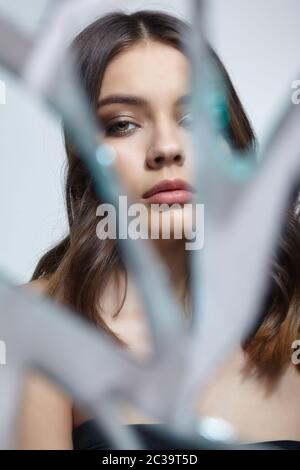 La giovane donna guarda in uno specchio rotto. Ritratto di bella femmina nei barili specchio Foto Stock