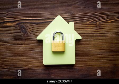 Concetto di sicurezza - serratura e figura della casa - su scrivania in legno top-down Foto Stock