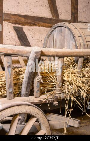 Vecchio carro da fieno con una cisterna per liquame su uno strato di paglia Foto Stock