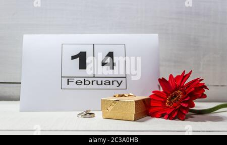 Scatola dorata con anelli di fiori e nota per il giorno di san valentino Foto Stock