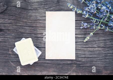 Foglio di carta in composizione con bouquet di lavanda fresca su vecchia scrivania di legno Foto Stock