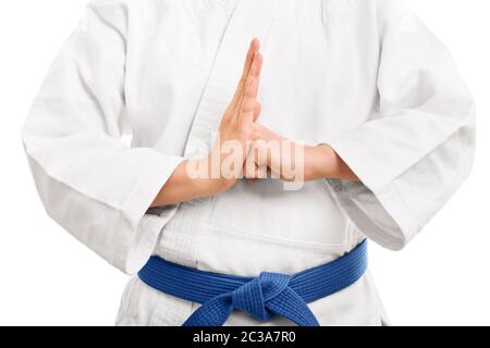 Un'immagine ravvicinata di un combattente martial di arti in un kimono bianco con cintura blu eseguendo una mano salutate, isolato su sfondo bianco. Foto Stock