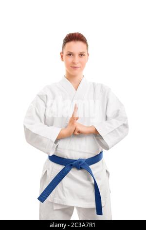 Ritratto di una bella combattente femminile di arti marziali in un kimono bianco con cintura blu che esegue un saluto a mano, isolato su sfondo bianco. Ragazza in un Foto Stock