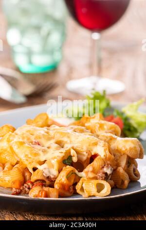 Porzione di una pasta gratinate su legno Foto Stock