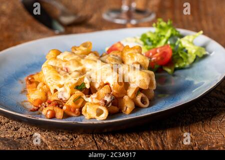 Porzione di una pasta gratinate su legno Foto Stock