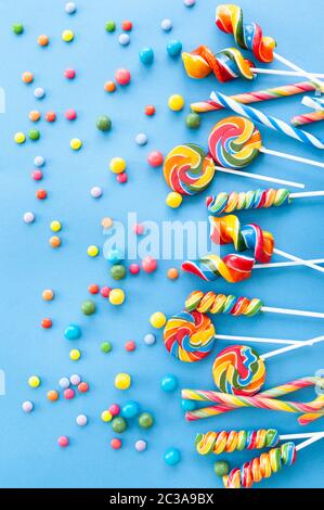 Caramelle colorate e lollipop su uno sfondo blu Foto Stock