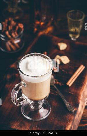 Irish coffee nel bicchiere su una superficie di legno Foto Stock