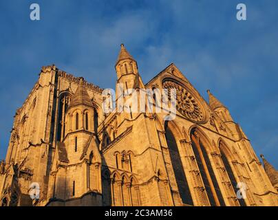 vista laterale della cattedrale di york alla luce del sole contro un cielo blu nuvoloso Foto Stock