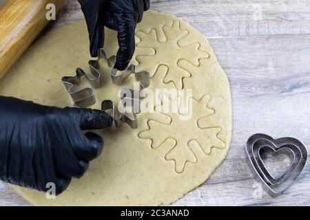 Preparazione di biscotti allo zenzero. Una forma metallica sotto forma di pan di zenzero per tagliare biscotti figurati. Simbolo di Capodanno. Foto Stock