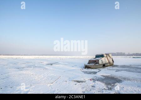 Barca intrappolata sul Danubio ghiacciato durante l'inverno 2017, a Zemun, Belgrado, Serbia con ghiaccio che fuoriesce dall'acqua. Questo inverno è stato particolarmente h. Foto Stock