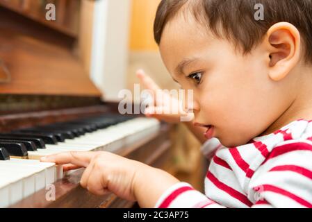 Cucciolata ragazzo suonando il pianoforte Foto Stock