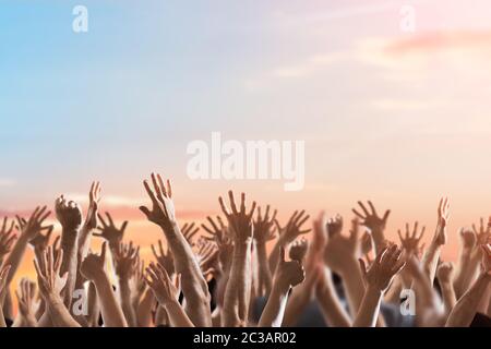 La folla di persone che allevano le mani a eventi celebrativi Foto Stock