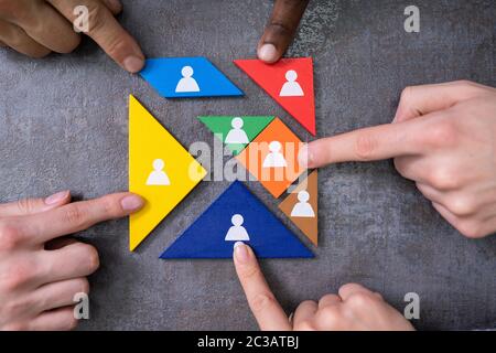 Imprenditore il Mani edificio Tangram blocco quadrato con figure umane Foto Stock