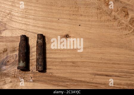 vecchia conchiglia arrugginita di artiglieria e proiettile di aerei su sfondo di legno, vecchie conchiglie arrugginite trovati proiettili della guerra mondiale 2, scavati fuori dal suolo Foto Stock