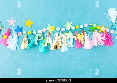 Decorazioni allegre e ghirlande da festa su sfondo blu Foto Stock