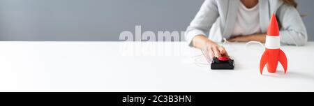 Imprenditrice la mano a razzo di lancio premendo il pulsante rosso Foto Stock