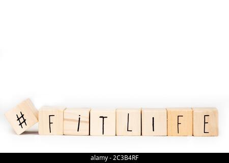 Cubi di legno con un hashtag e la parola Fitlife isolato su sfondo bianco, sano e sociale concetto di sport Foto Stock