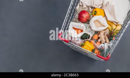 Frutta, verdura, cereali in sacchetti di tessuto riutilizzabile nel carrello. Vista dall'alto o in piano. Spazio di copia. Carrello con primo piano di cibo, studio shot. FO Foto Stock