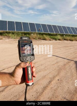 Manor Texas USA, 2012: Bianco maschio utilizza termocamera per eseguire il controllo di qualità e controllare le cellule difettose presso la Webberville Solar Farm, il più grande progetto solare attivo di qualsiasi utilità pubblica nel paese. Ha oltre 127.000 moduli e può generare più di 61 milioni di kWh di elettricità, Texas - 2012. ©MKC / Daemmrich Photos Foto Stock