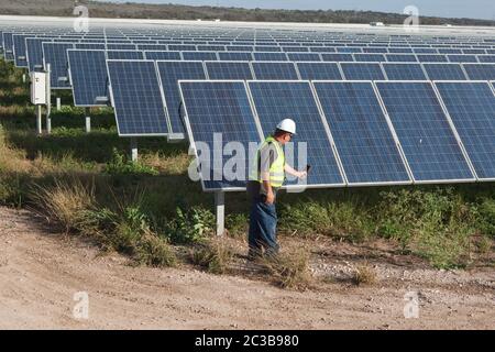 Manor Texas USA, 2012: Bianco maschio utilizza termocamera per eseguire il controllo di qualità e controllare le cellule difettose presso la Webberville Solar Farm, il più grande progetto solare attivo di qualsiasi utilità pubblica nel paese. Ha oltre 127.000 moduli e può generare più di 61 milioni di kWh di elettricità, Texas - 2012. ©MKC / Daemmrich Photos Foto Stock