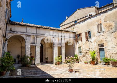 30 giugno 2019 - Amelia, Umbria, Terni, Italia - un antico edificio nel centro della città. Le vecchie pareti in pietra e mattoni, il cortile con portico Foto Stock