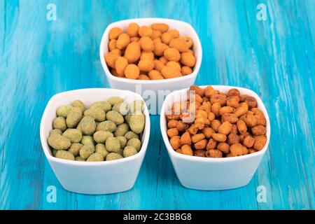 Mix di noci in wasabi e pastella spezia su sfondo di legno. Foto Stock