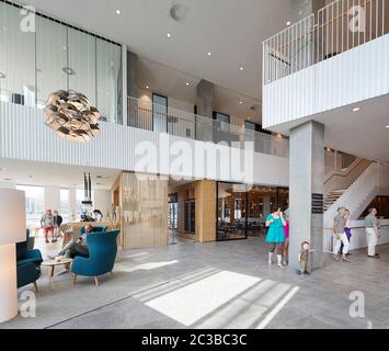 Area arrivi e ricevimenti con salotto. Hotel Alsik, Sønderborg, Danimarca. Architetto: Henning Larsen, 2019. Foto Stock