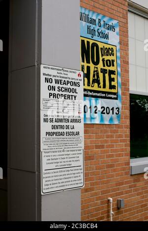 Austin, Texas USA, giugno 3 2014: La scuola superiore pubblica mostra segni bilingue, richiesti dalla legge statale, che affermano che non sono consentite armi sulle proprietà scolastiche, insieme a un poster che annuncia che la scuola non ha "alcun posto per l'odio". ©Marjorie Kamys Cotera/Daemmrich Photography Foto Stock