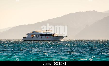 Grande barca sullo sfondo di alte montagne in Egitto Dahab Sinai Sud Foto Stock