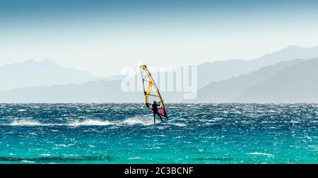 Windsurf scorre su uno sfondo di alta montagna in Egitto Dahab Sinai del Sud Foto Stock