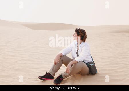 Donna calma seduta sulla sabbia Foto Stock
