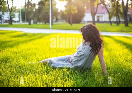 Donna incinta che riposa sul prato Foto Stock