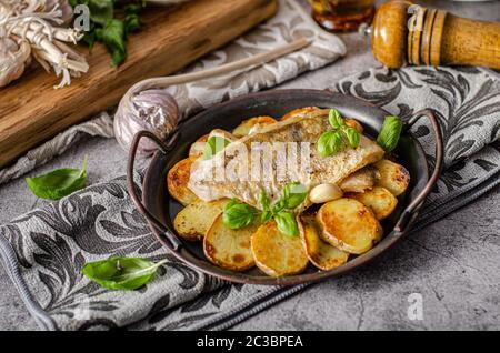 Delizioso pesce con patate arrosto e bio aglio Foto Stock