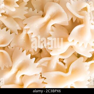 Primo piano di fondo di pasta di farfalle. Le farfalle sono un tipo di pasta/noodle comunemente noto come pasta con cravatta o pasta con farfalla. Foto Stock