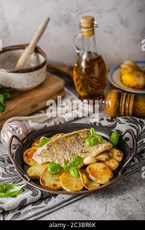 Delizioso pesce con patate arrosto e bio aglio Foto Stock