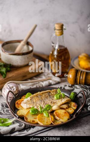 Delizioso pesce con patate arrosto e bio aglio Foto Stock