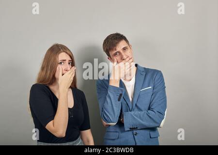 Scioccato coprente bocca con le mani spaventato, si sentono orribili acrobazie guardare, muto Foto Stock