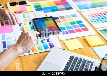 Professional architetto creativi graphic desiner professione scegliendo il colore Pantone campioni di tavolozza per il progetto sul desktop dell'ufficio Foto Stock