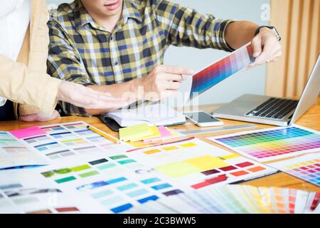 Professional architetto creativi graphic desiner professione scegliendo il colore Pantone campioni di tavolozza per il progetto sul desktop dell'ufficio Foto Stock