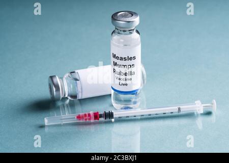 Il morbillo parotite rosolia fiale di vaccino con siringa su sfondo turchese Foto Stock