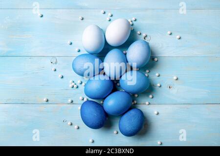 Concetto di Pasqua. Ombre uova in blu su sfondo di legno blu con spazio per la copia del testo. Vista dall'alto o in piano. Colori blu classici a Pasqua Foto Stock