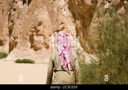 beduino in bianco va nel canyon nel deserto tra le rocce in Egitto Dahab Sinai Sud Foto Stock