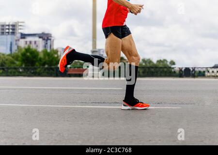 uomo runner in calze nere di compressione correre maratona città Foto Stock