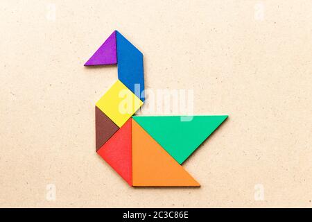 Puzzle tangram colore in forma di cigno o anatra su sfondo di legno Foto Stock