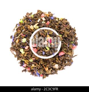 Tè Guan Yin cravatta con boccioli di rosa, frutta candita, petali di fiori di mais, isolato su sfondo bianco. Tè biologico. Vista dall'alto. Primo piano. Foto Stock