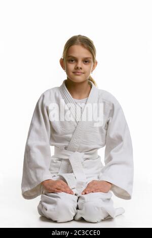 Ragazza in classe judo, seduta sul pavimento Foto Stock