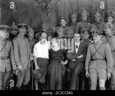 Direttore CECIL B. DeMILLE stella MARY PICKFORD Consulente tecnico Capitano IAN HAY BEITH del film extra dell'esercito britannico RAMON NOVARRO (parzialmente nascosto a destra di Hay) E JACK HOLT su set candid durante le riprese del regista AMERICANO LITTLE 1917 CECIL B. DeMILLE scrittore Jeanie Macpherson Mary Pickford Company / Artcraft Pictures Corporation Foto Stock