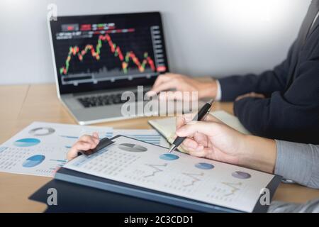 Imprenditori parlando di mercato azionario investire trading online analisi discutendo grafico finanziario a fini di investimento in discussione gli operatori office Foto Stock