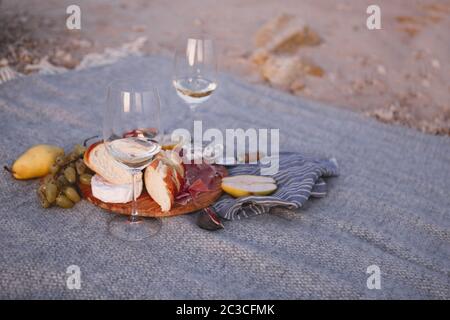 Stuzzichini e frutta appetitosi con vino al picnic Foto Stock
