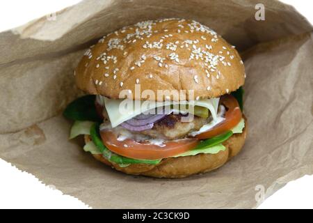Hamburger su wrapper bianchi. Vecchio tavolo in legno con hamburger. Lattuga succosa e focaccine calde. Hamburger saporiti nel bistro locale. Foto Stock